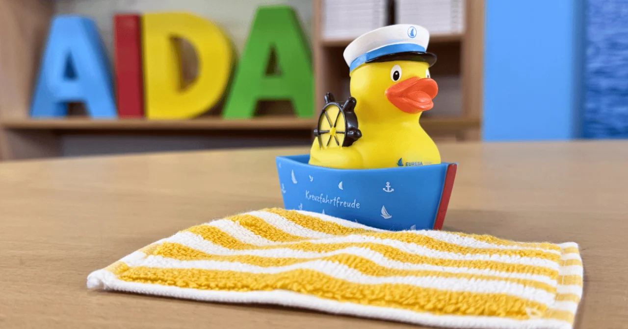 AIDA Handtuch und EURESAreisen Quietscheente als Symbolbild für AIDA Geburtstags-Sale mit limitiertem AIDA Handtuch als Beigabe