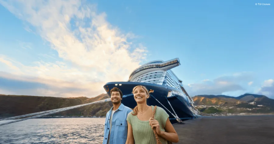 Paar vor Mein Schiff im Hafen als Header für Beitrag zu Mein Schiff Septemberkampagne 2026 mit auslaufender Frühbucher-Ermäßigung für Kreuzfahrten im Sommer 2027