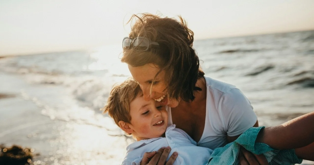 Fröhliche Mutter mit Kind am Meer