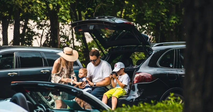 Familie macht Autofahrt-Pause auf Parkplatz